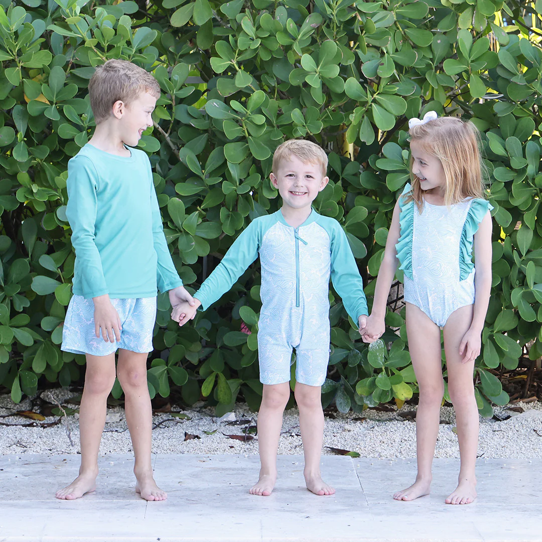 Kids in matching wave print swimsuits 