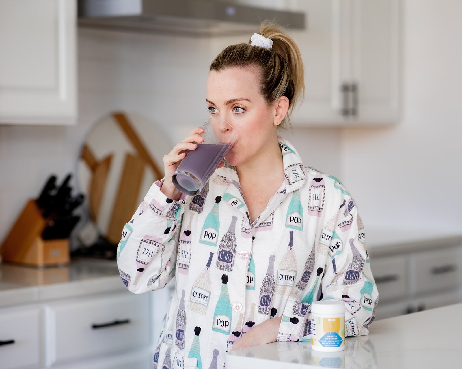 Woman in pajamas drinking her Majka Magnesium drink.