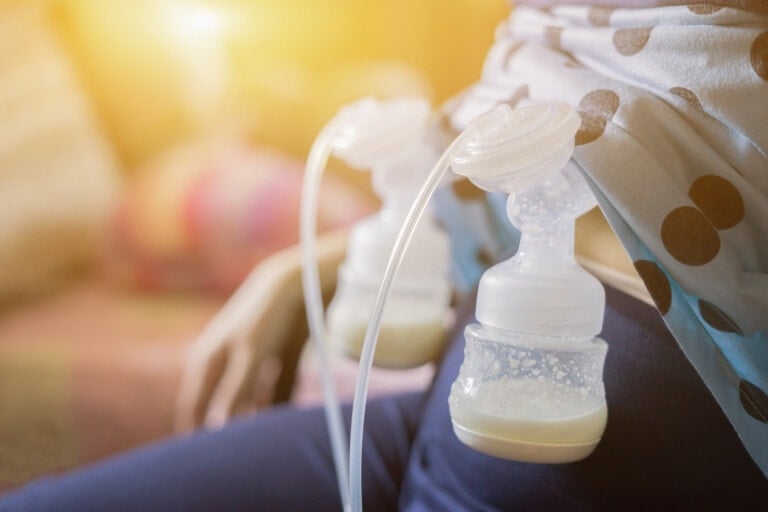 Cropped photo of woman using her breast pump and pumping breast milk.