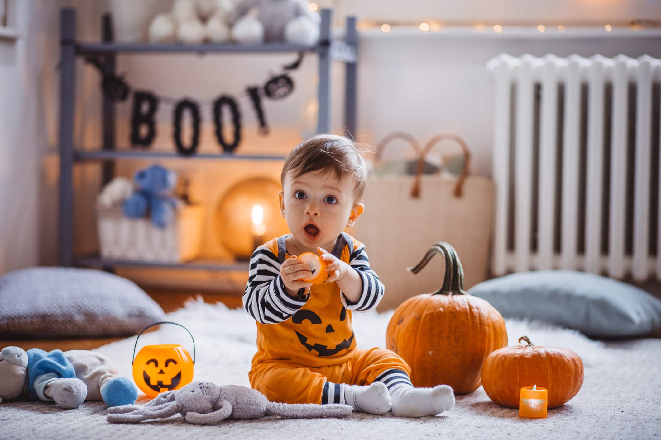 Baby boy wear costume and playing on floor on Halloween