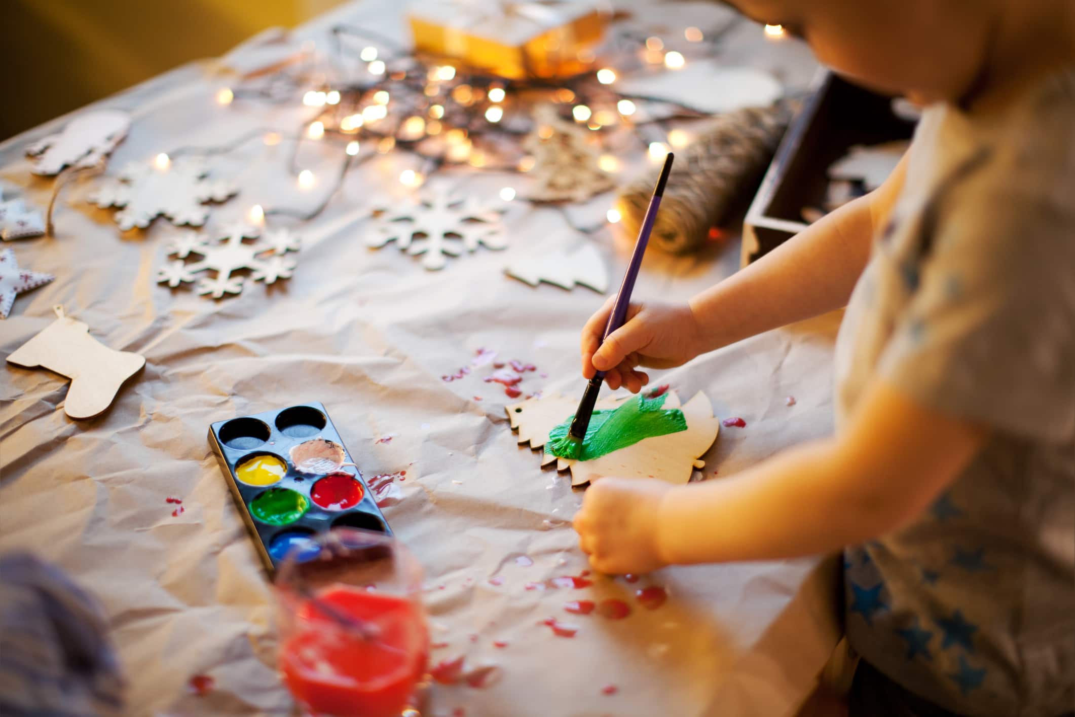 Little boy painting a wooden Christmas ornament