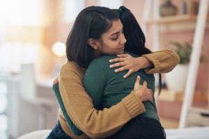Cropped shot of two young women embracing each other at home