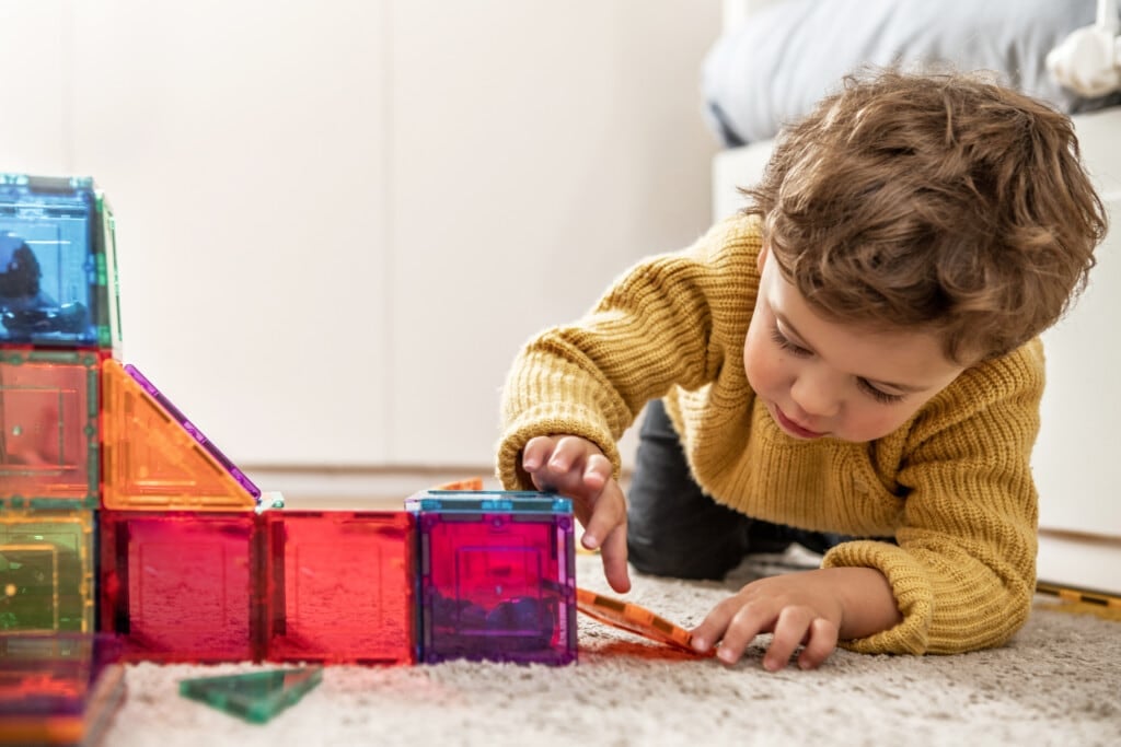 Boy playing with magna-tiles toys.