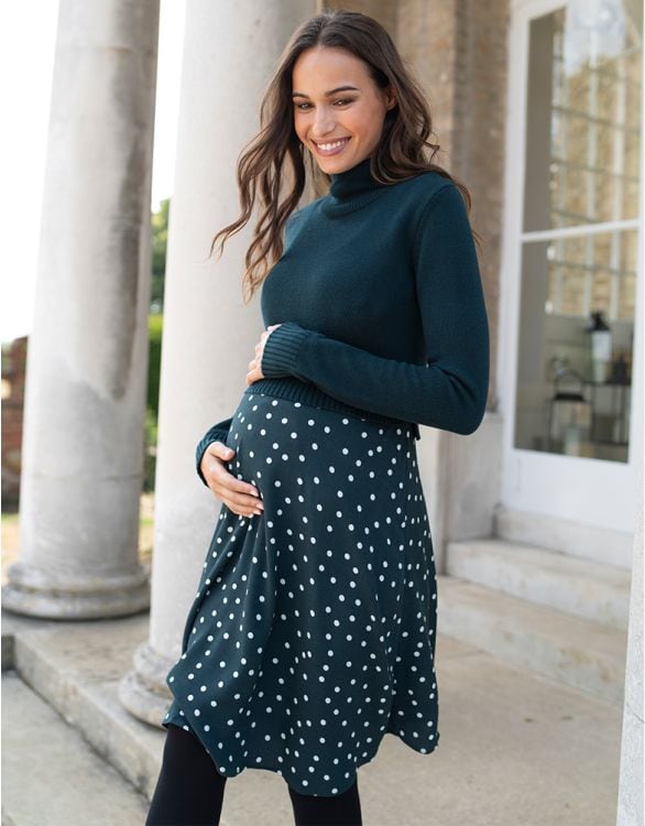 Woman in green polka dot maternity dress