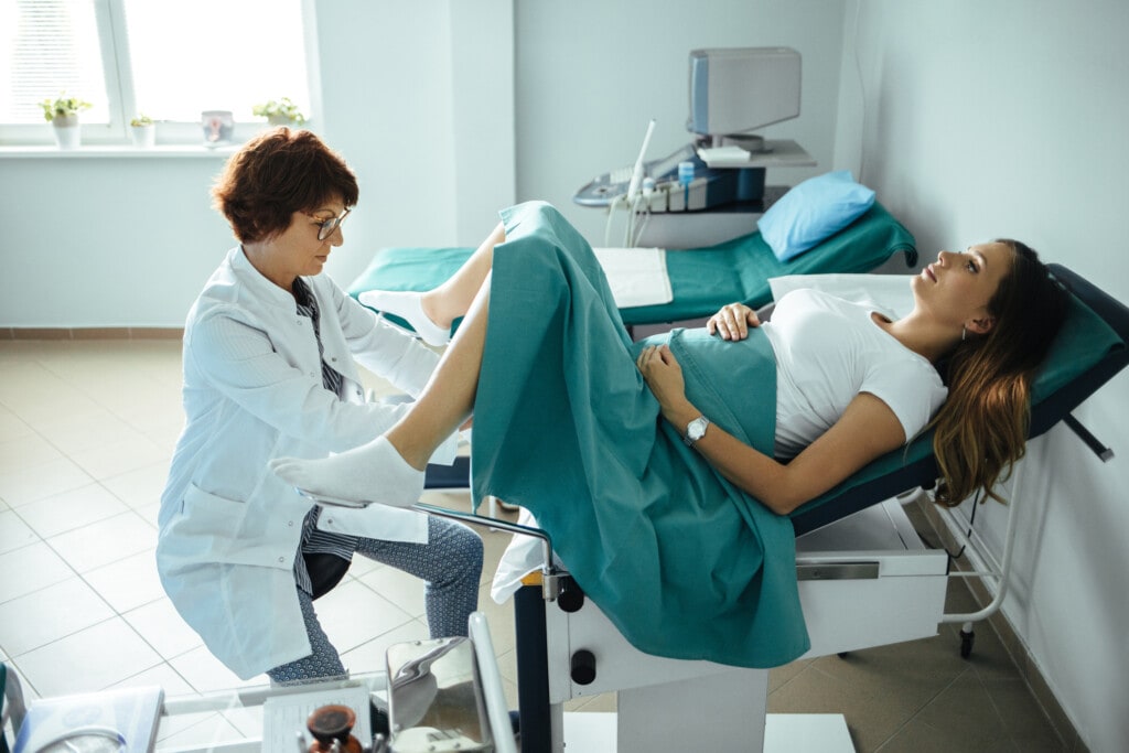 Pregnant woman at gynecologist appointment getting an exam.