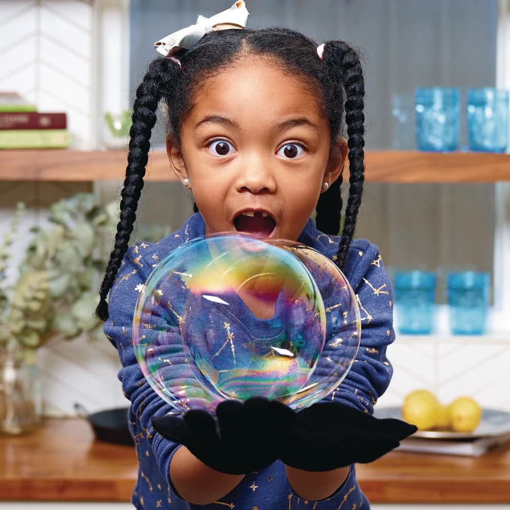 Girl holding and amazed by bubbles