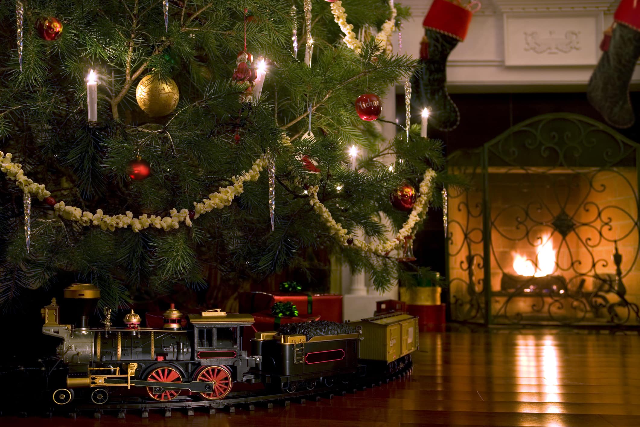 A toy train under a Christmas tree.