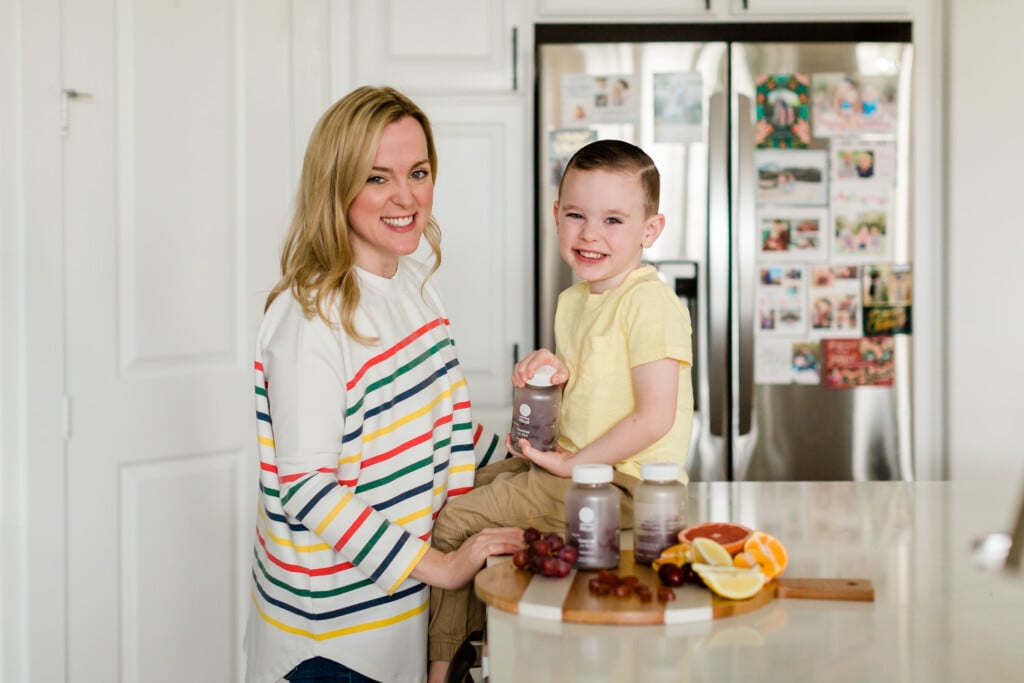 Mother with her son in the kitchen giving him his Ritual Essential for Kids Multivitamin.