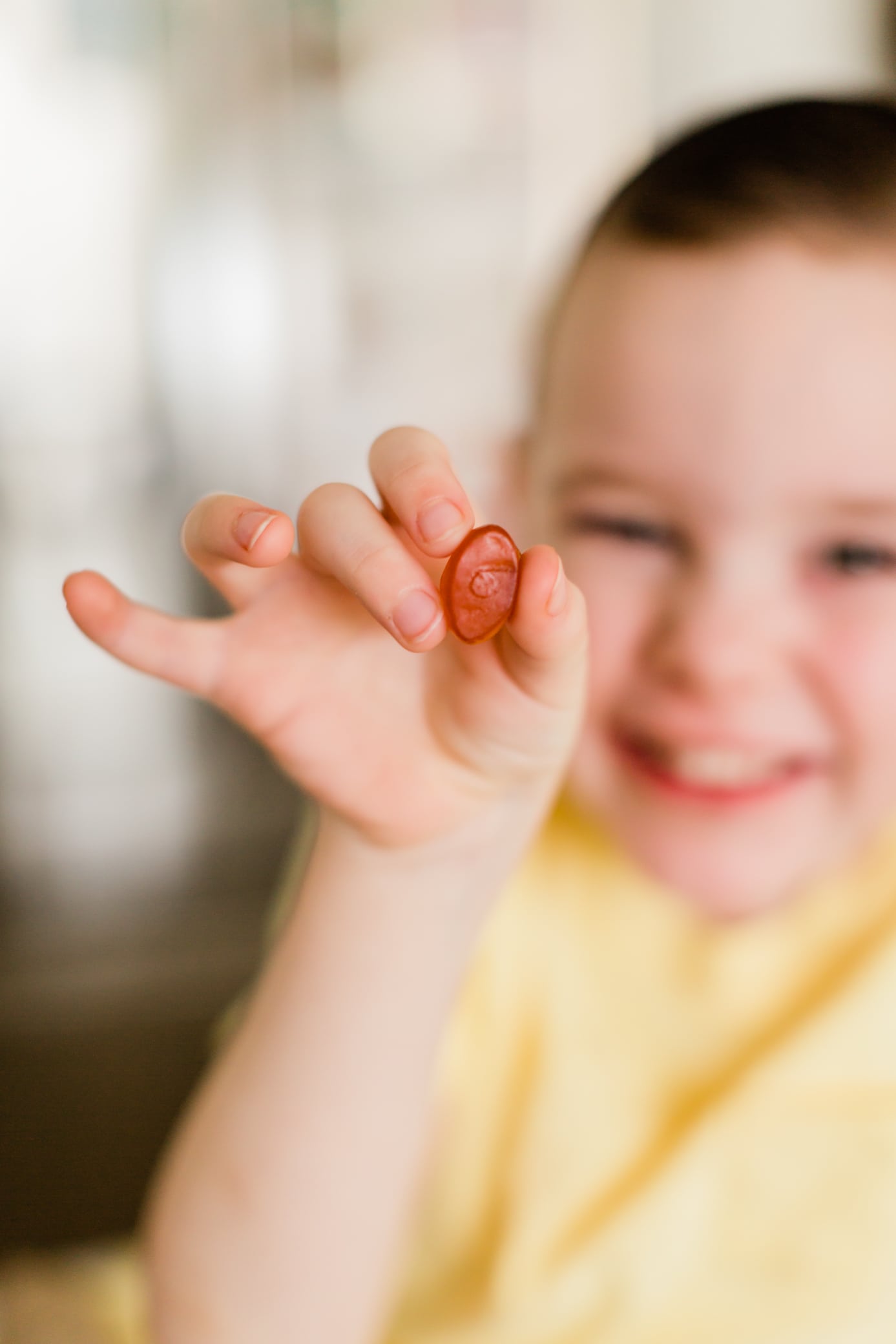 Boy holding up a gummy Ritual Kids Multivitamin