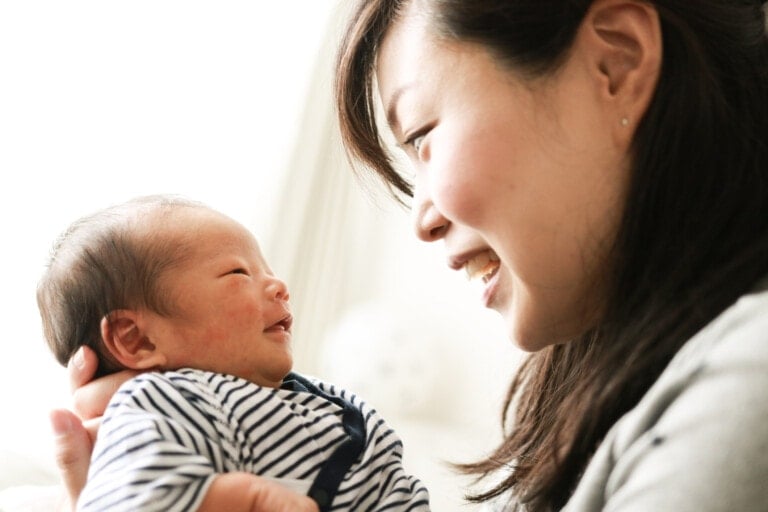 Asian mother is smiling with 8-days old her baby
