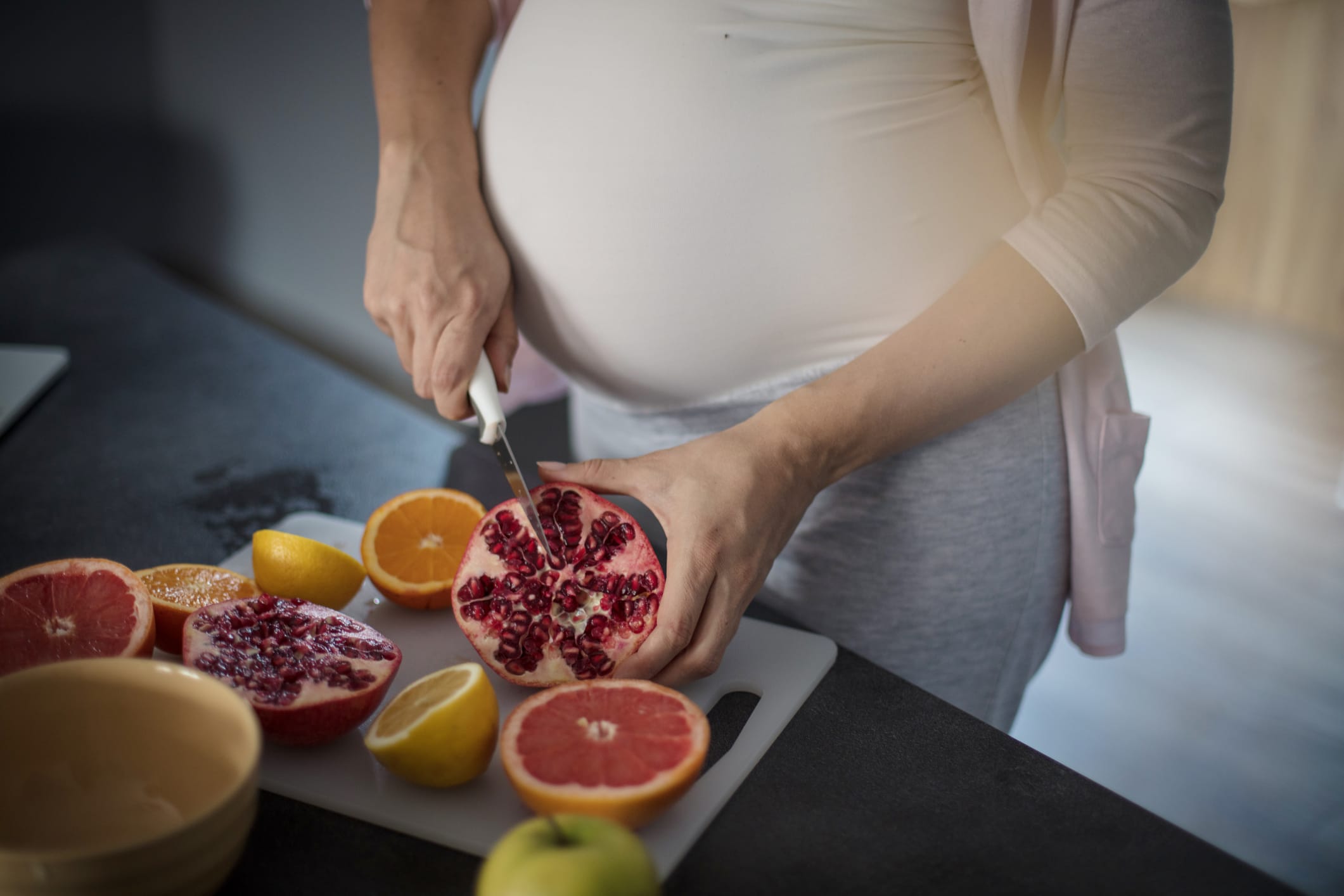 It has to be healthy for the baby. Pregnant woman in kitchen. Close up. Focus on hands.
