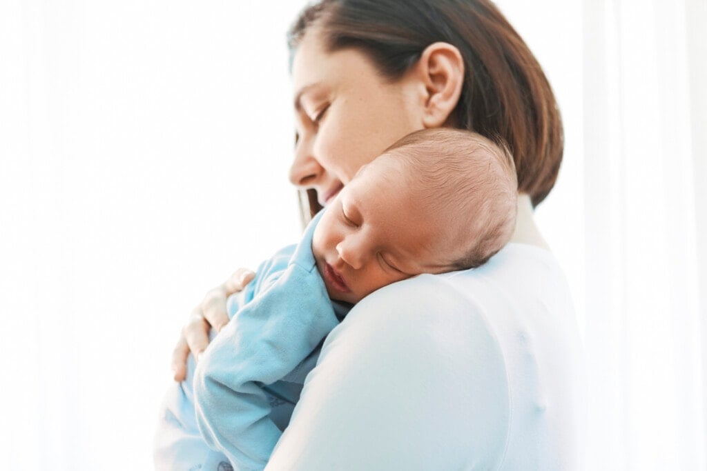 Mother with newborn son cuddling