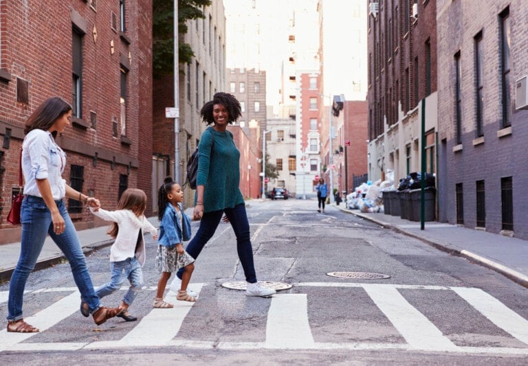 Two mother friends with two daughters crossing the road