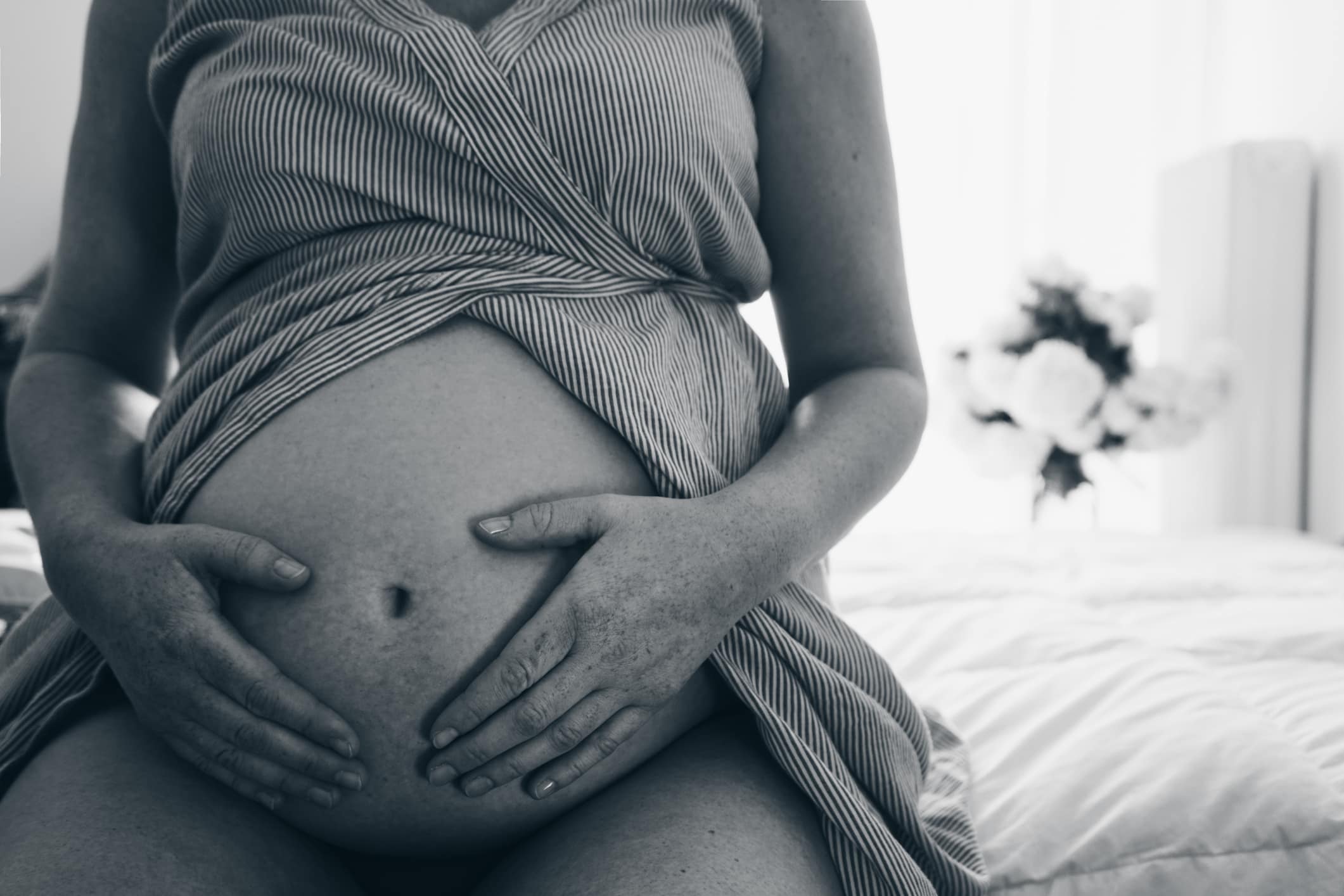 Close up of pregnant woman touching her belly with hands