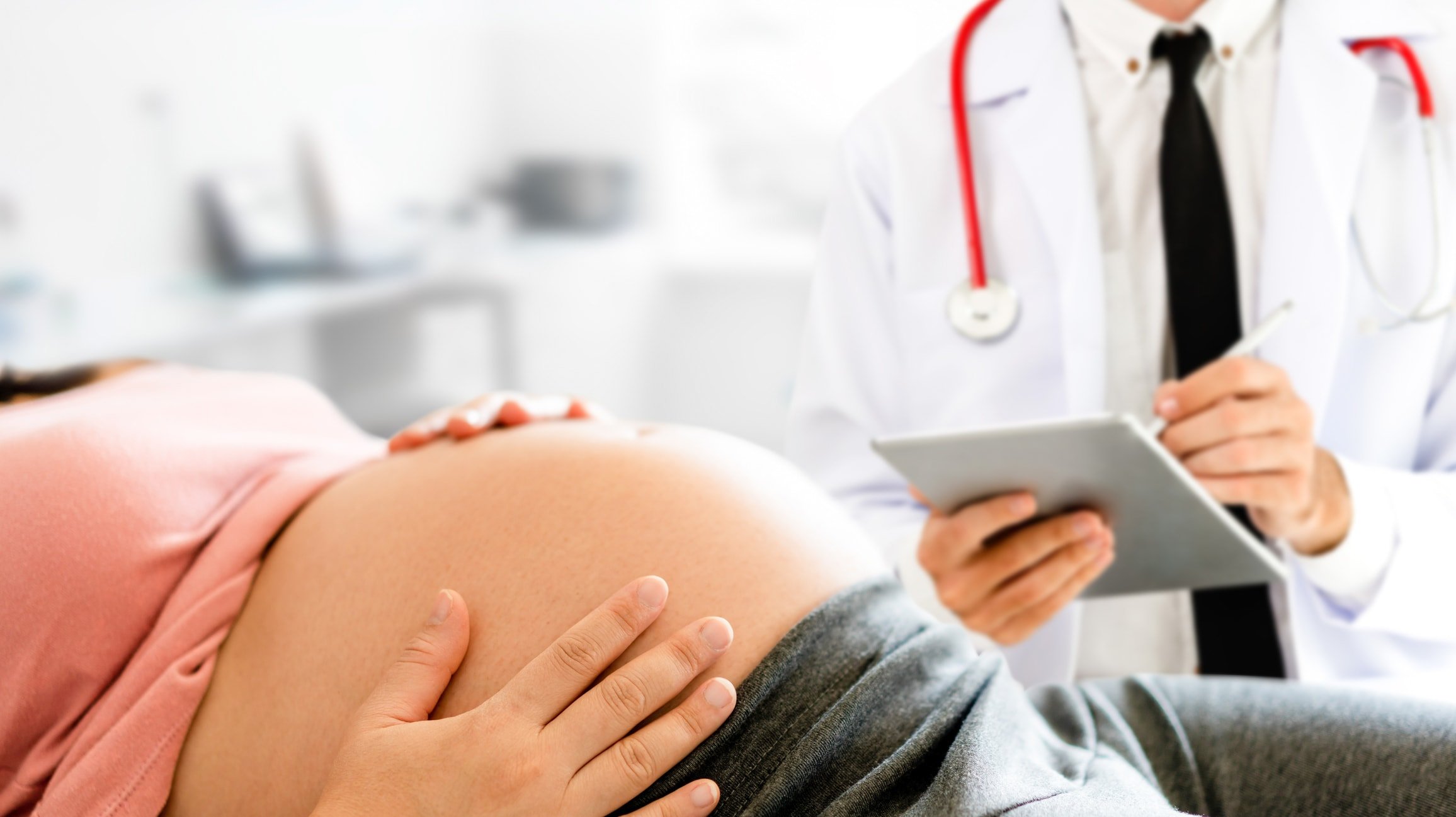 Happy pregnant woman visit gynecologist doctor at hospital or medical clinic for pregnancy consultant. Doctor examine pregnant belly for baby and mother healthcare check up.