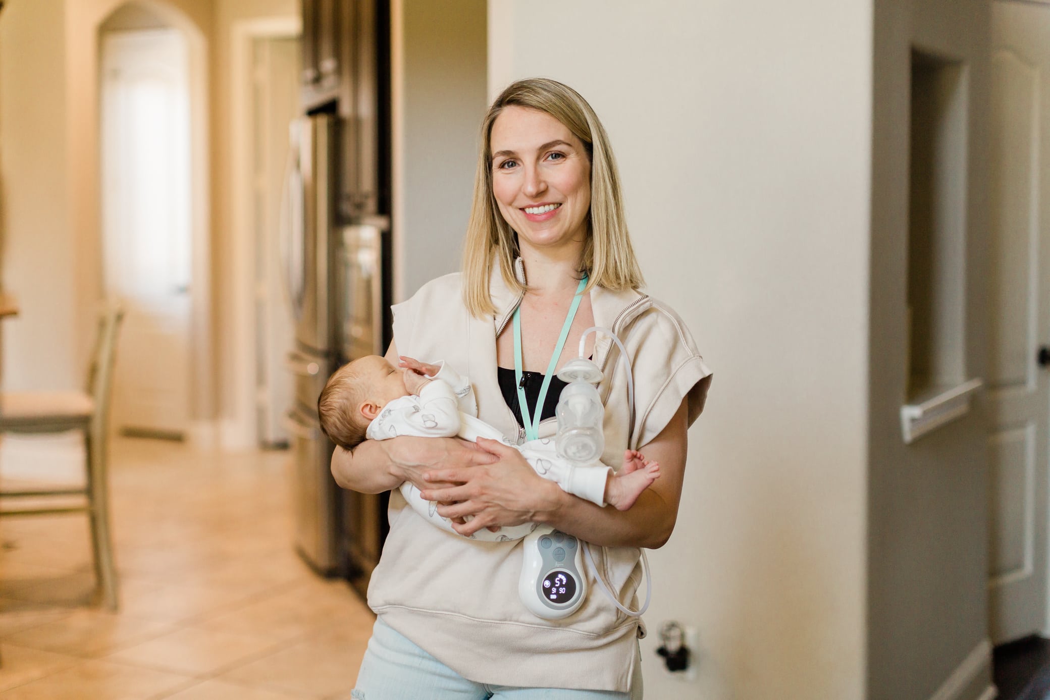A mom holding her newborn baby while using the Motif Duo.