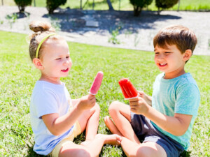 Kids sitting outside enjoying homemade popsicles.