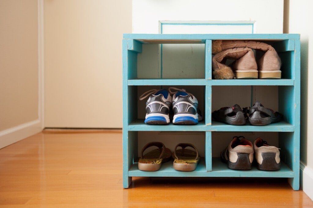 Shoes on a blue rack, shot on a wood floor with soft light and negative space.