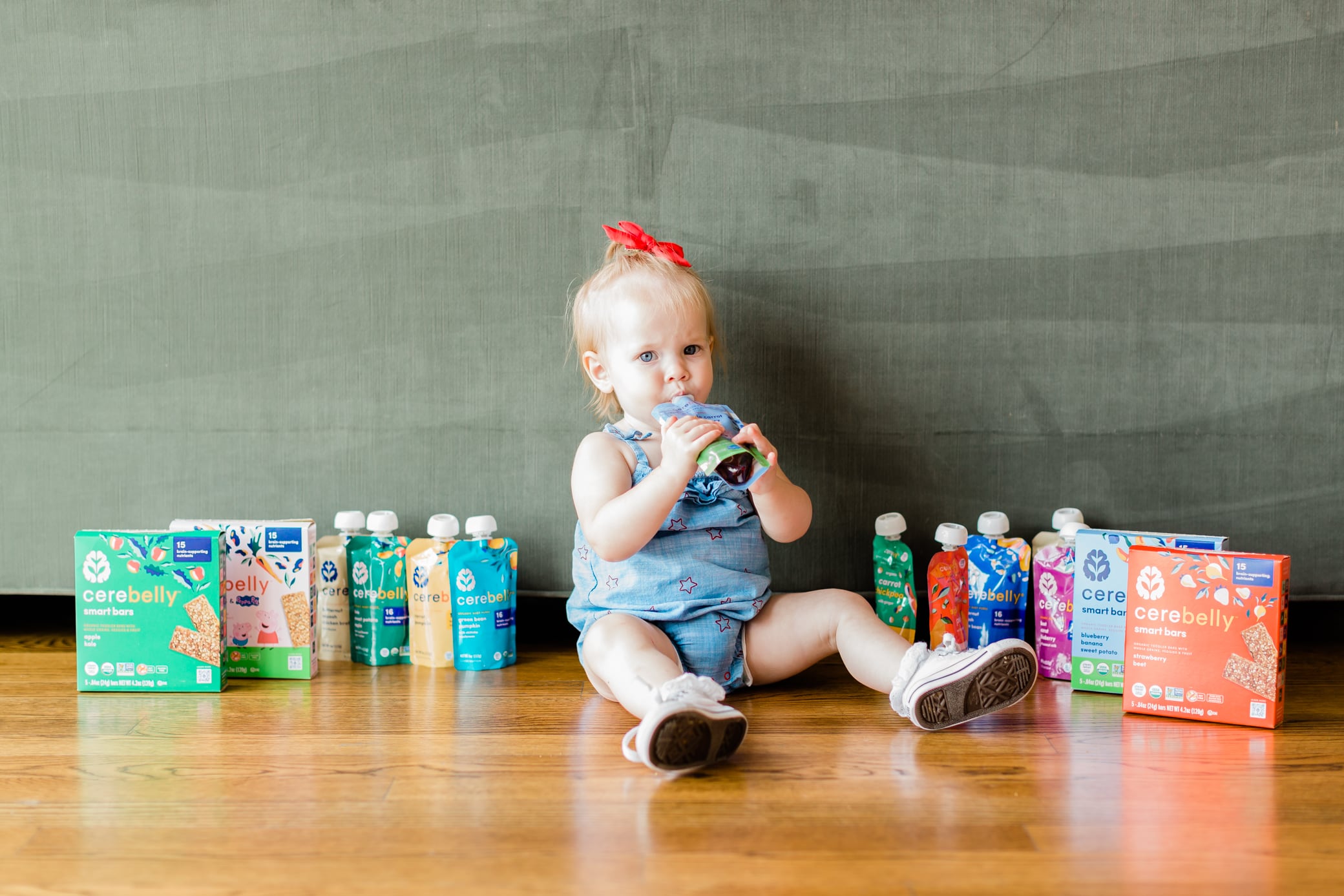 Toddler girl sitting on the floor with Cerebelly products.