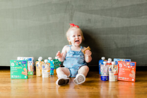 Toddler girl sitting on the floor with Cerebelly products.