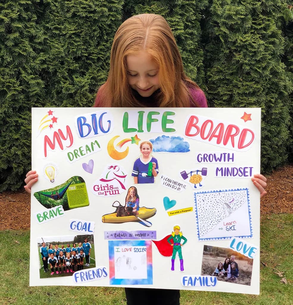 Girl holding up her vision board.