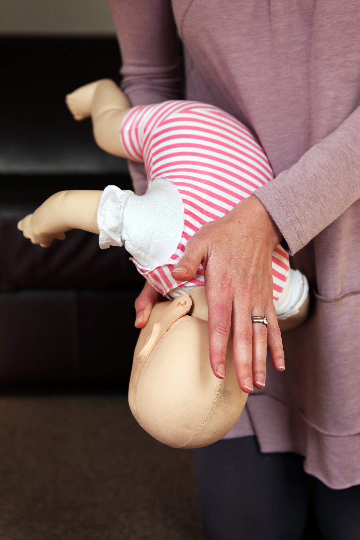 Woman showing on a dummy what to do when a baby is choking.