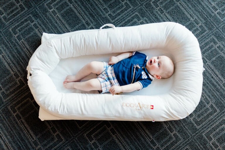 Baby boy laying in a dockatot.