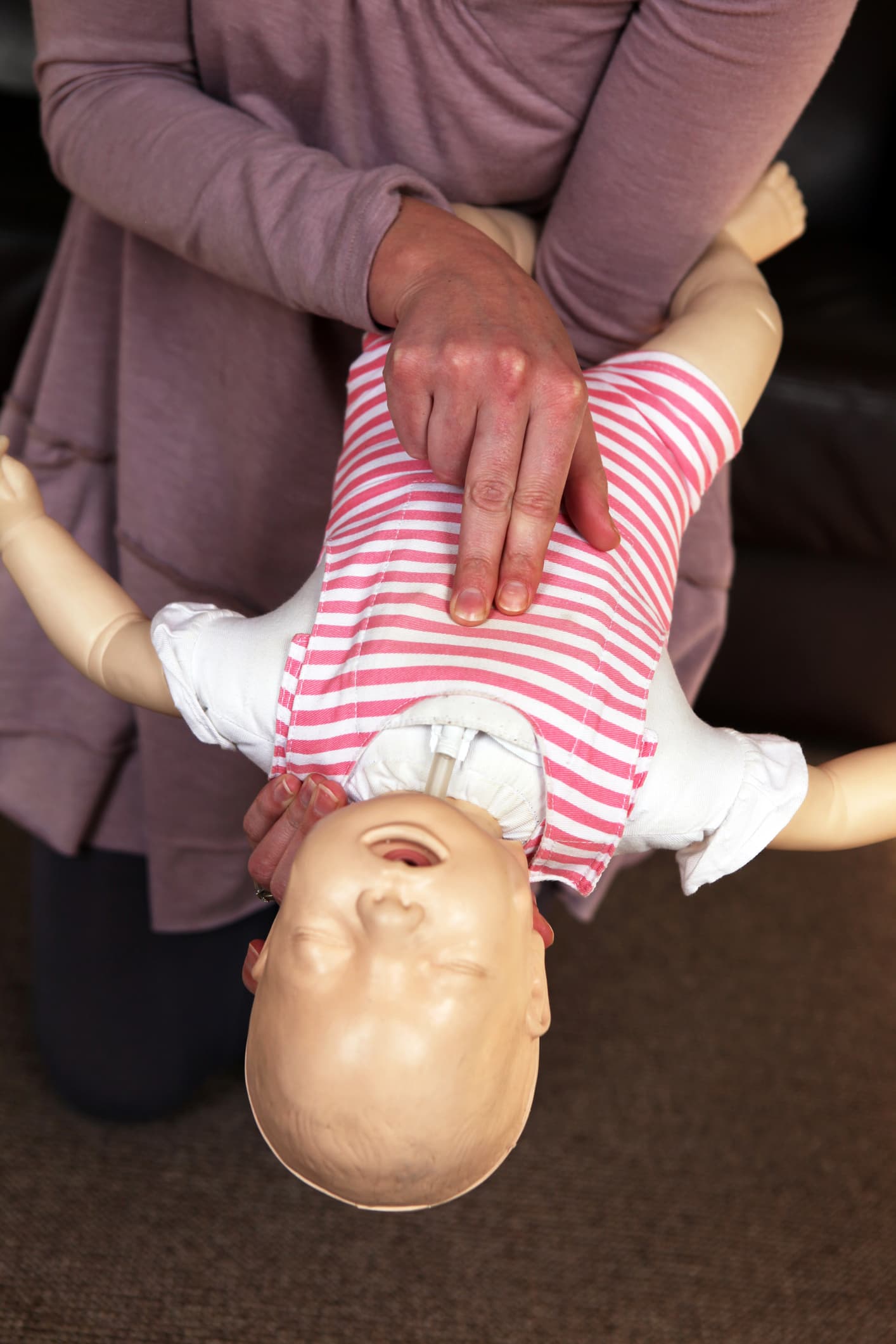 Infant choking training, showing where to push and to hold the baby when choking.