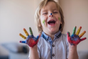 Cute little boy is having fun with finger paint