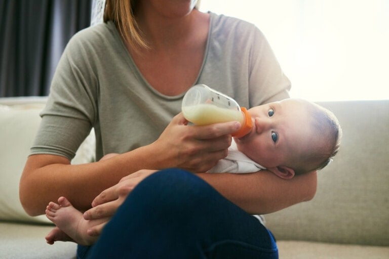 Shot of an unrecognizable mother feeding her baby a bottle at home