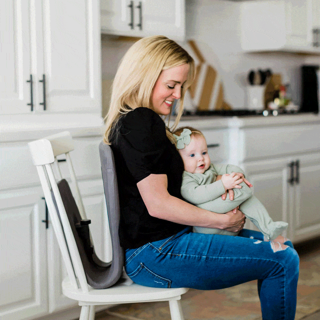 Mom holding her baby girl while sitting on a chair using the Ready Rocker