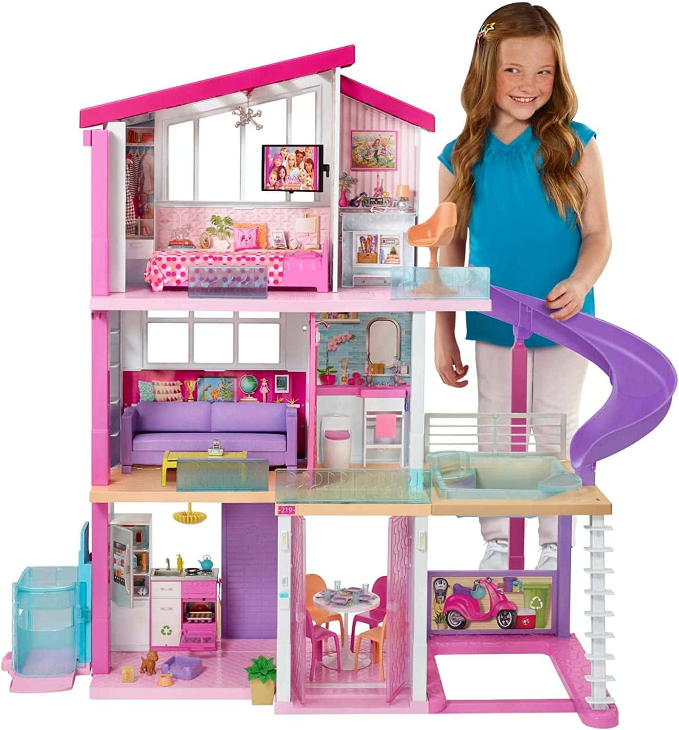 3-story dollhouse with slide and little girl standing next to it 