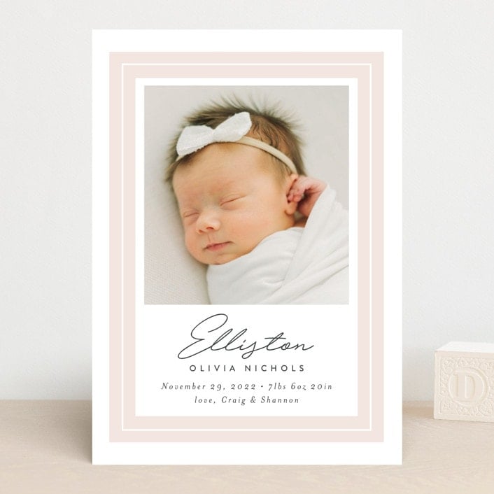 White card with pink border around photo of baby girl with birth announcement.