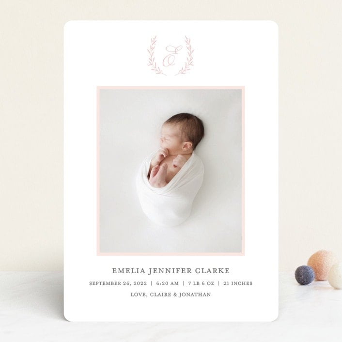 White rectangle card with a photo of a baby in the middle and monogram above. Birth announcement text at the bottom of the card. 
