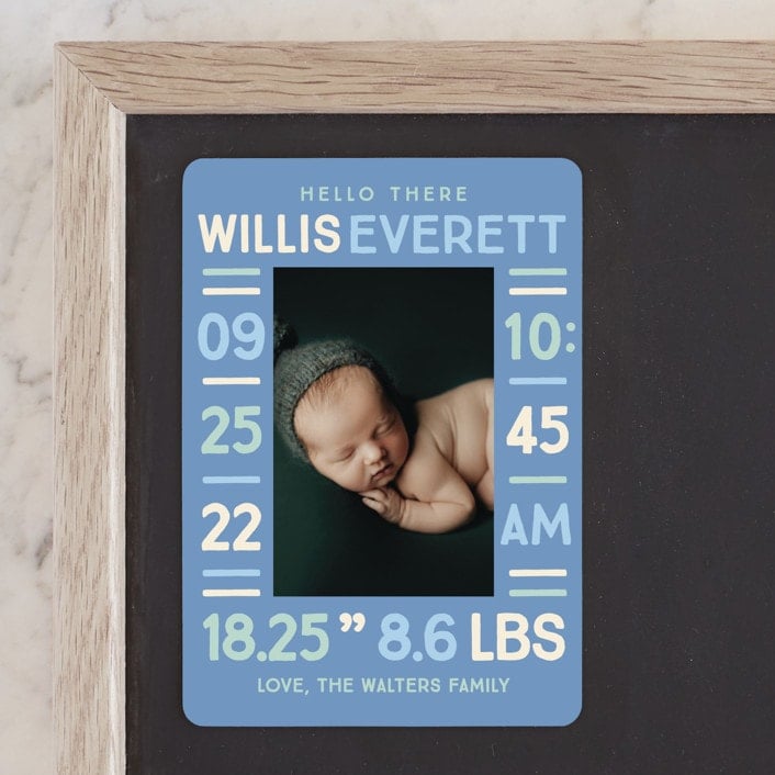 Blue card with a photo of a baby in the middle and birth announcement text around the photo.