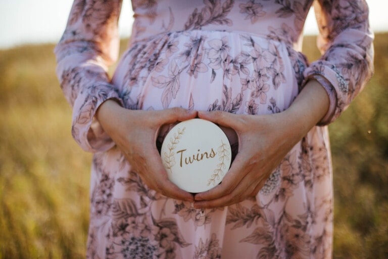 Photo of a pregnant woman holding a sign that says 