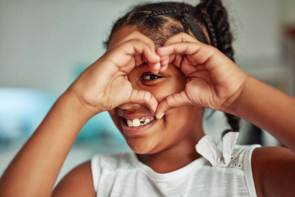 Cropped shot of a young girl forming a heart shape with her hands around her eye.