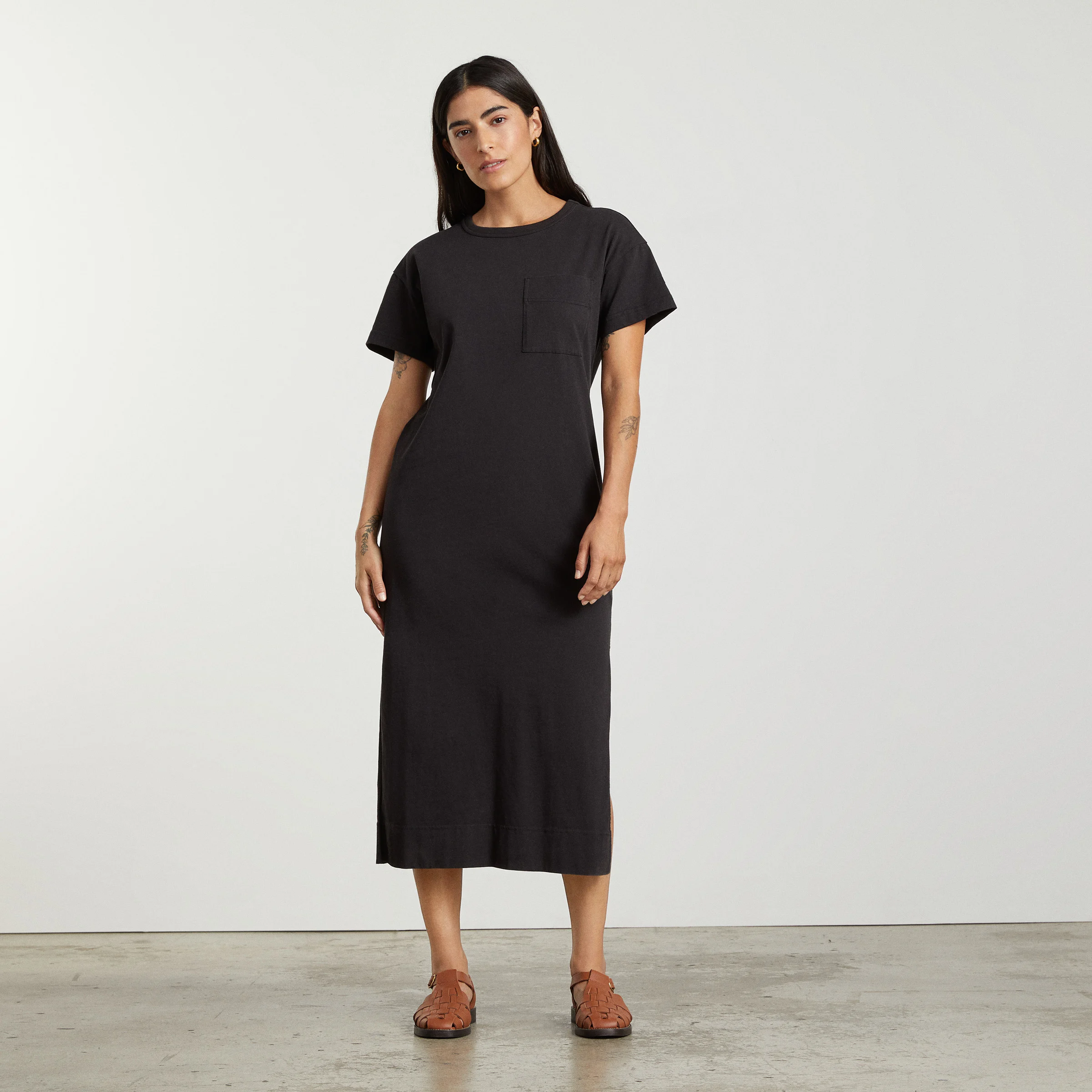 Woman in black midi dress with front pocket 