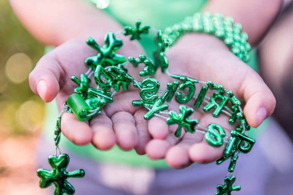 Little girl with Saint Patrick necklace in her hands.