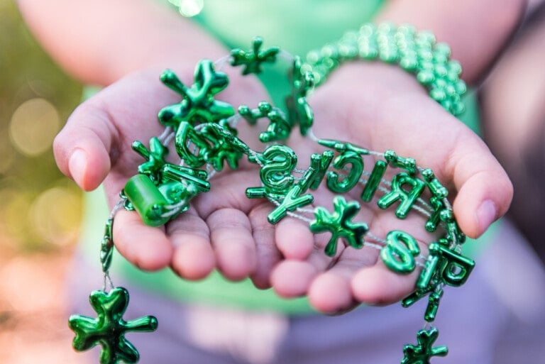 Little girl with Saint Patrick necklace in her hands.