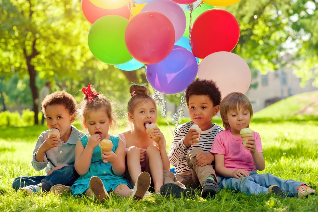 Children with colorful balloons and ice-cream in the park