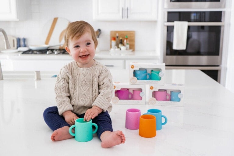 Baby sitting on a kitchen counter with PopYum silicone cups