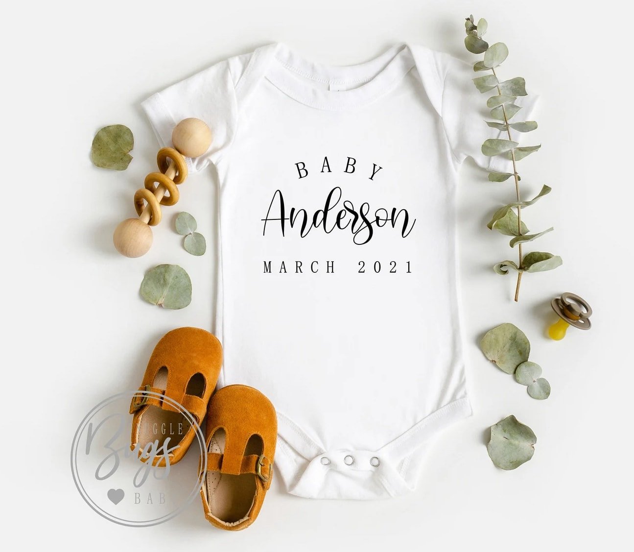 White baby announcement onesie with baby shoes 