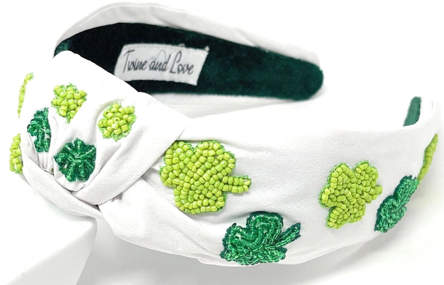 White knotted headband with green shamrocks on it 