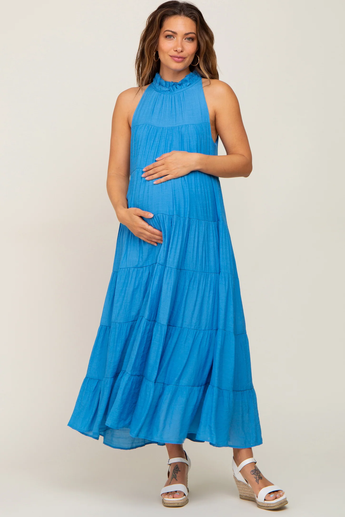 Woman in blue high-neck long maternity dress
