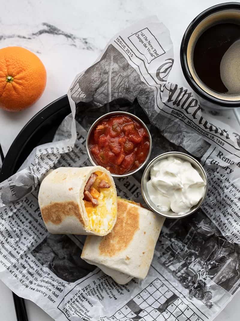 Freezer-Friendly Breakfast Burritos on a newspaper dish sitting on a table.