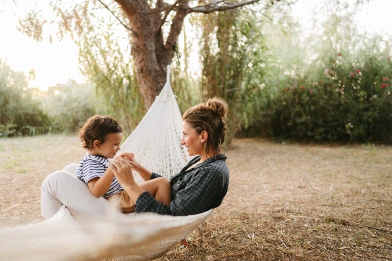 Photo of a little boy and his mother having a relaxing moment in a hammock