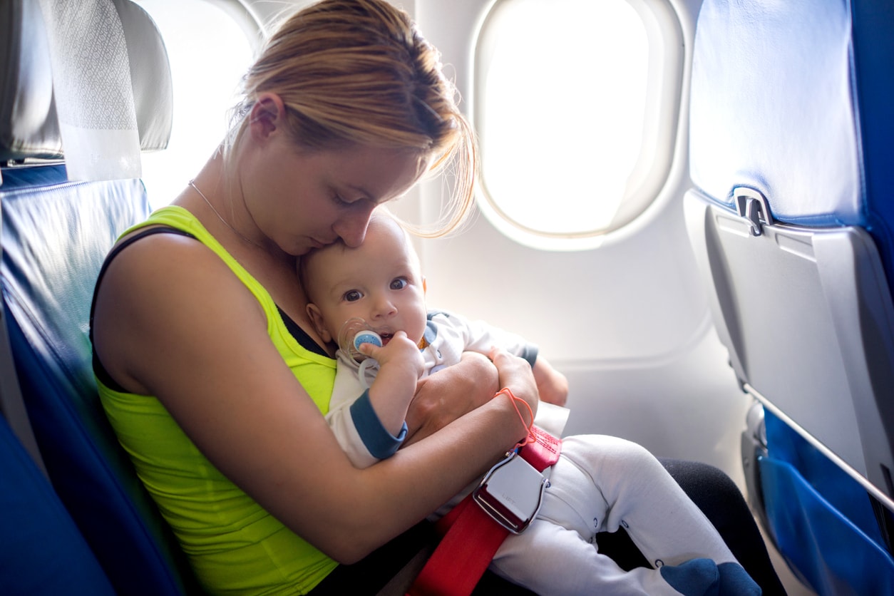 Young mother and her baby boy traveling by plane.