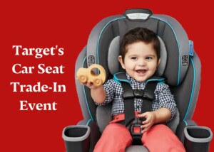 Toddler in car seat holding up a toy - Target's Car Seat Trade In event