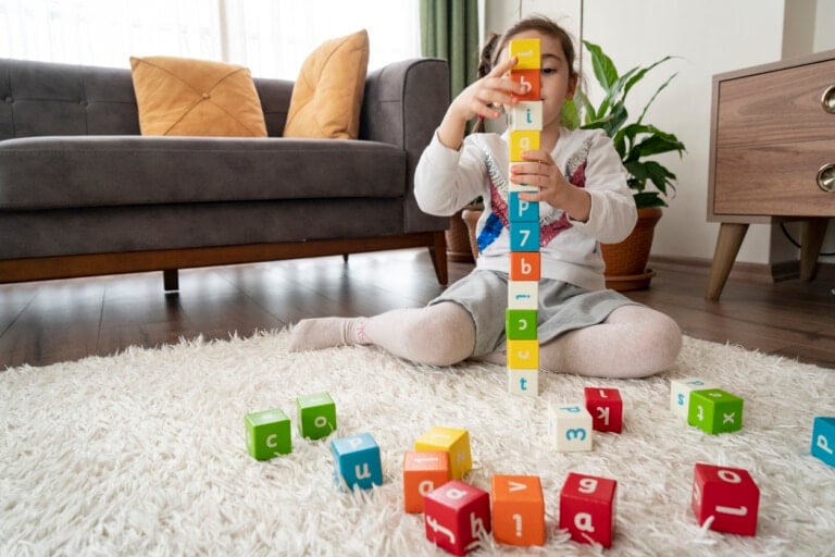 Kid playing with colorful blocks at home
